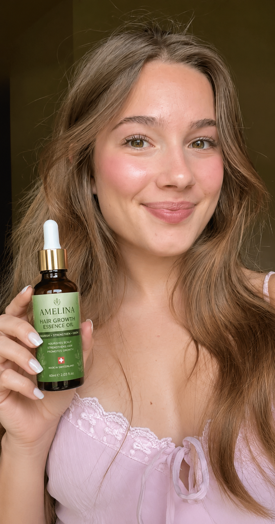 Happy AMELINA customer holding the Hair Growth Essence Oil bottle